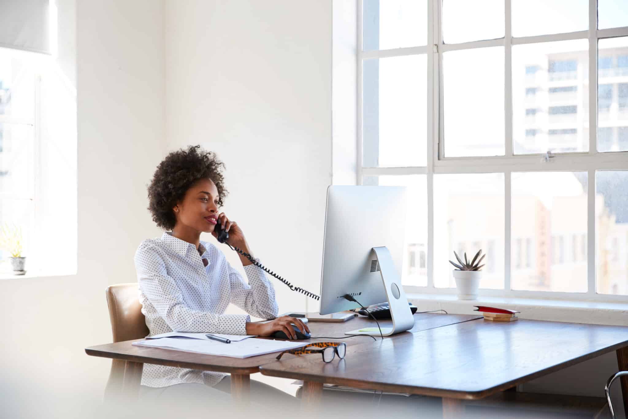 Woman sitting in sun at desk